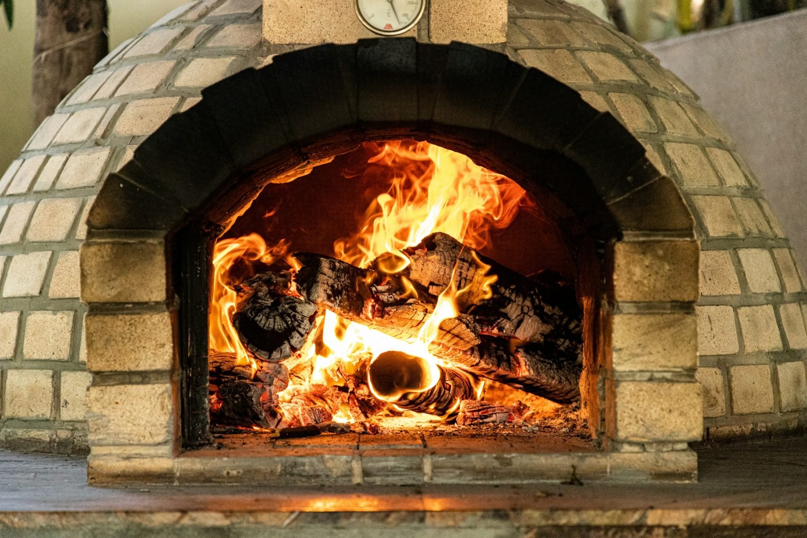 Brick dome pizza oven with a wood fire burning inside