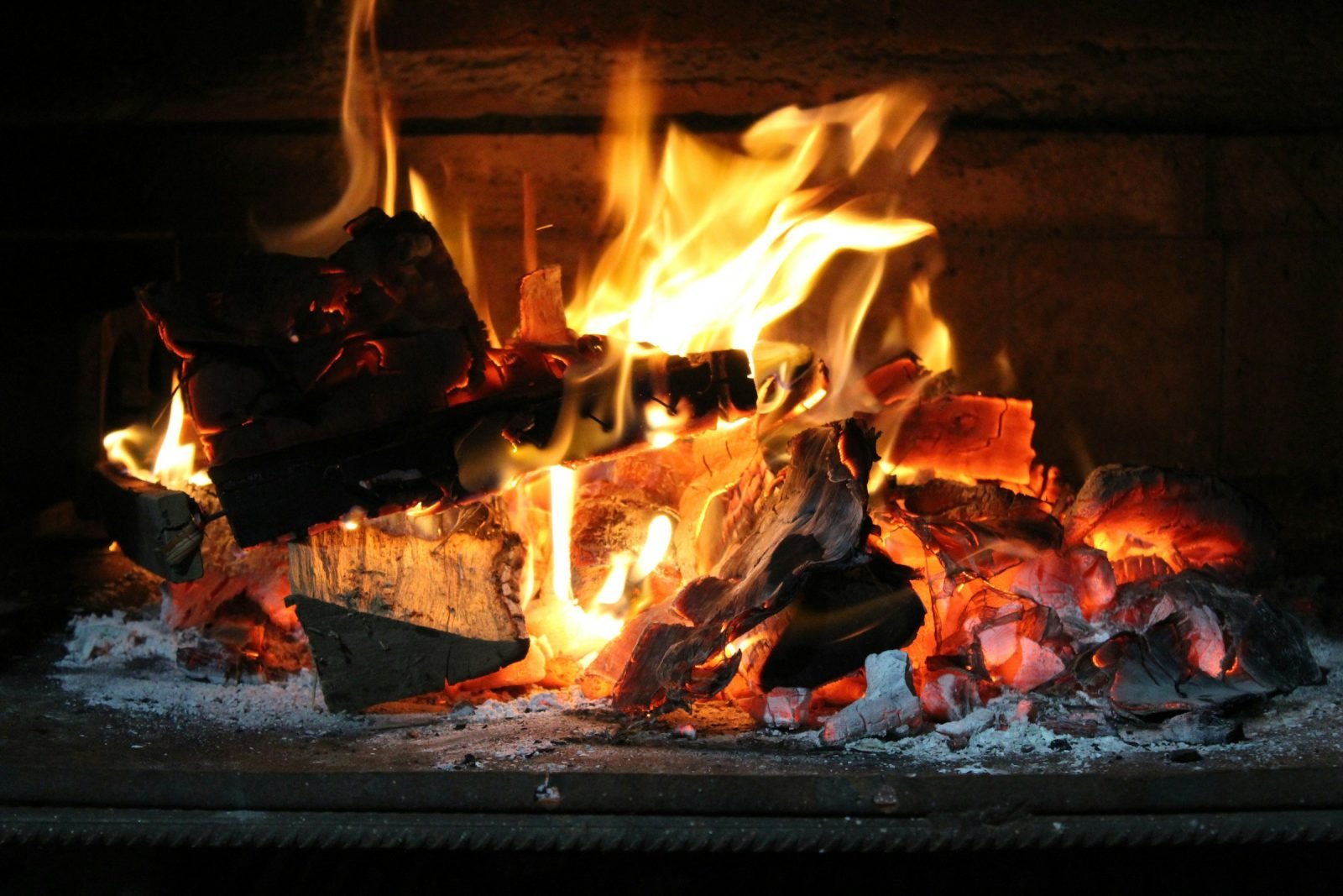 Hardwood logs burning down to glowing embers
