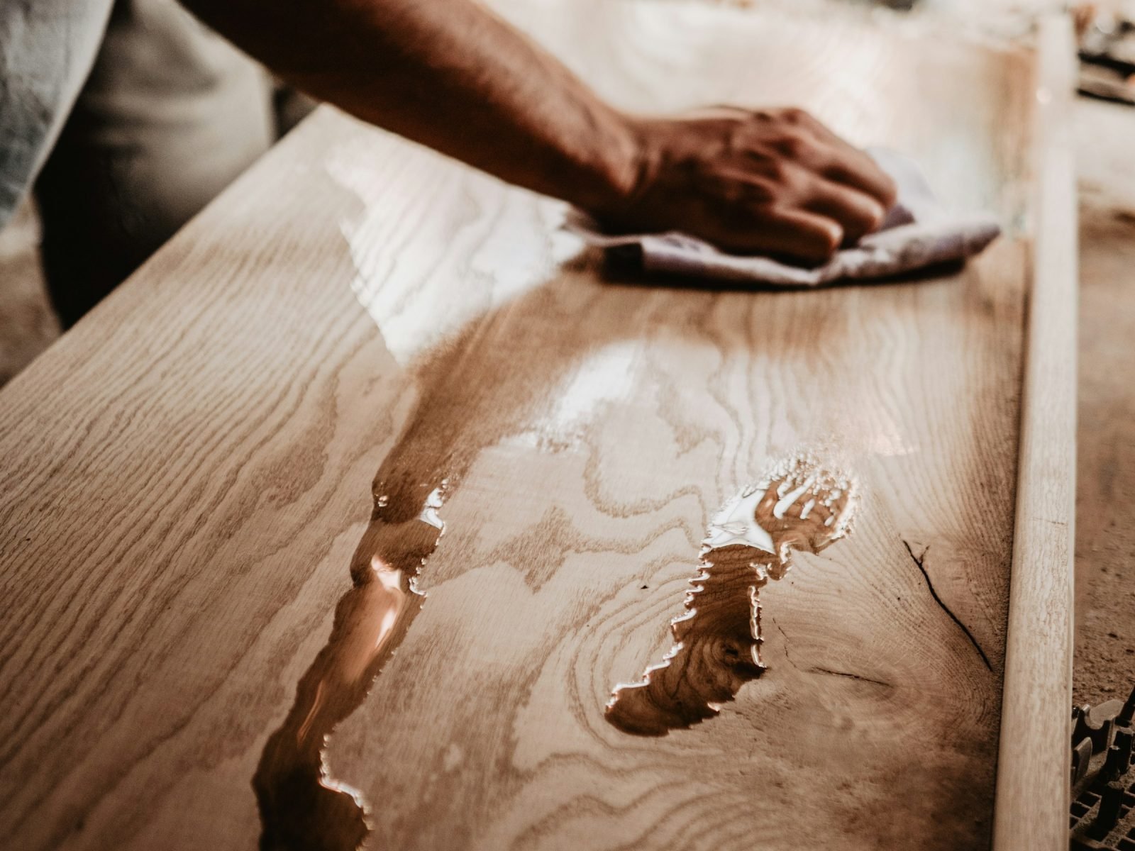 Hand wiping a wooden counter with a cloth
