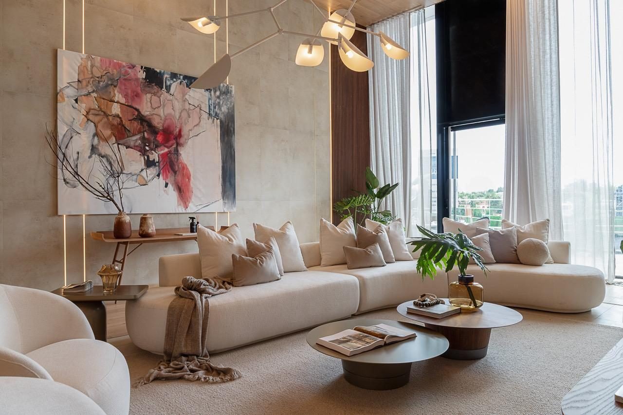 Living room styled with a large abstract painting, curved sofa and branch chandelier