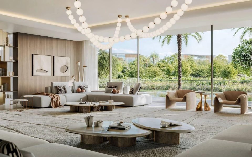 Light living room with a pearl-strand chandelier, curved sofas, sculptural chairs and garden views
